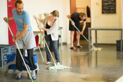 A group of people lying on their backs on yoga mats in a class, some with blindfolds on.