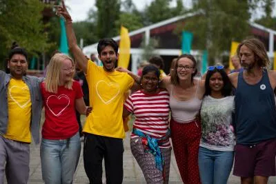 A diverse group of people smiling and walking together outdoors in a celebratory mood