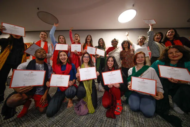 A group of people celebrating together while holding up framed certificates.