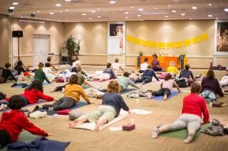 A group of people attending a yoga class event with instructor Shweta Bhanot.